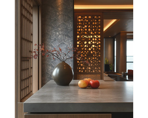 Modernes Interieur mit Arbeitsplatte in Steinoptik, Keramikvase mit Beerenzweigen, Äpfeln, strukturierter Wand und dekorativem Holz-Raumteiler.