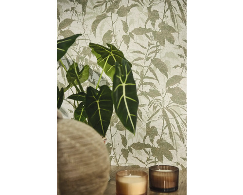 Vliestapete mit botanischem Blattmuster in wohnlicher Umgebung mit Alocasia Pflanze und Kerzen.