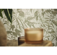 Vliestapete mit botanischem Blatt- und Zweigemuster in einer Raumsituation mit Kerzen und Pflanzen.