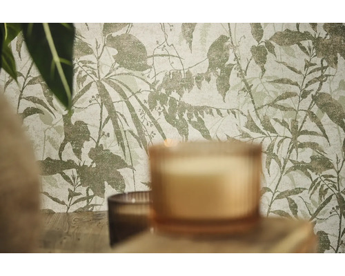 Vliestapete mit botanischem Blatt- und Zweigemuster in einer Raumsituation mit Kerzen und Pflanzen.