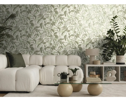 Helles Wohnzimmer mit botanisch gemusterter Tapete, weißem Modulsofa, einem Glastisch mit Steinkugeln und verschiedenen Zimmerpflanzen.