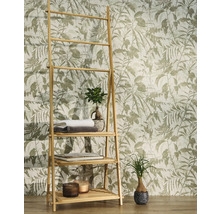 Vliestapete mit botanischem Blattmotiv und Vögeln hinter einem Bambusregal mit Handtüchern und Pflanzen in einem hellen Raum.