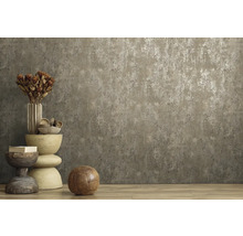 Vliestapete mit Betonoptik und metallischem Effekt an einer Wand in einem Raum mit Holzboden und Dekoration.