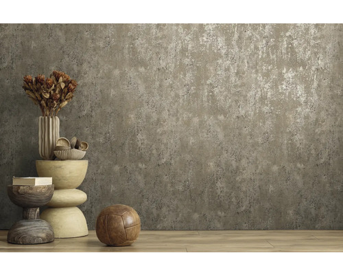 Vliestapete mit Betonoptik und metallischem Effekt an einer Wand in einem Raum mit Holzboden und Dekoration.