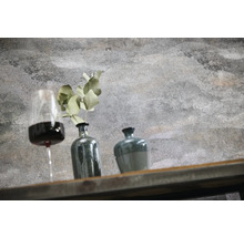 Wand in strukturierter Betonoptik mit Dekoration aus Weinglas, Vase mit Pflanze und Gefäß auf einem Holzregal.