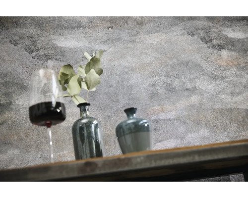 Wand in strukturierter Betonoptik mit Dekoration aus Weinglas, Vase mit Pflanze und Gefäß auf einem Holzregal.