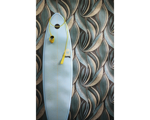Vliestapete mit stilisiertem Blättermuster in Grün und Beige, davor steht ein hellblaues Surfbrett mit gelber Leine.