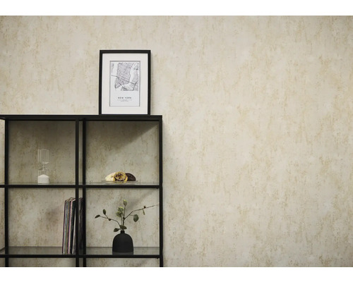 Vliestapete in beige Betonoptik an einer Wand hinter einem schwarzen Metallregal mit dekorativen Objekten.