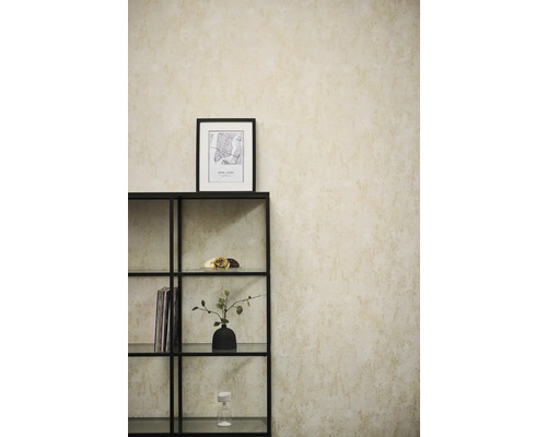 Vliestapete mit strukturierter Optik an einer Wand hinter einem schwarzen Metallregal in einem hellen, modern eingerichteten Raum.