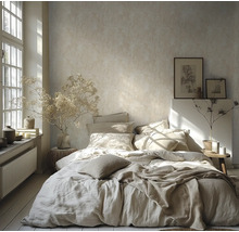 Helles Schlafzimmer mit strukturierter Tapete, Bett mit Leinenbettwäsche, Trockenblumen in Vasen und großem Fenster für natürliches Licht.