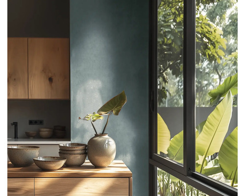 Moderne Küche mit Holzschränken, Keramikschalen und einer Vase auf einer Holzoberfläche neben einem Fenster mit Blick auf grüne Pflanzen.