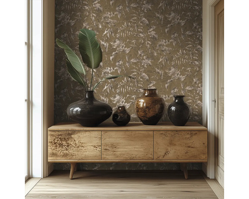 Hölzernes Sideboard vor einer Wand mit Tapete mit Blättermuster, dekoriert mit verschiedenen dunklen Vasen und großen grünen Blättern.