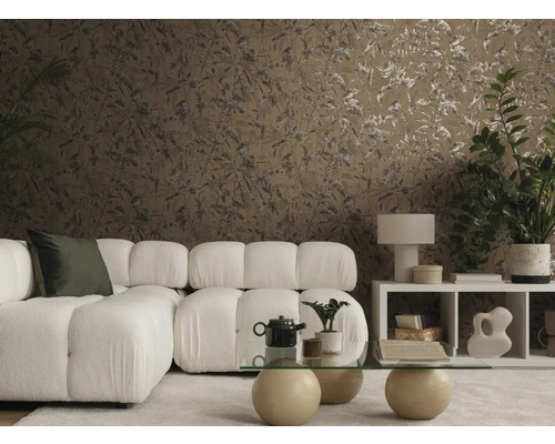 Modernes Wohnzimmer mit braun gemusterter Tapete mit Blattmotiven, einem weißen Modulsofa und einem gläsernen Couchtisch in wohnlicher Atmosphäre.