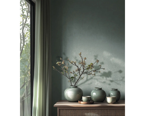 Wandgestaltung mit grüner Wandfarbe, drei Keramikvasen mit Krakelee-Glasur und Zweigen auf einem Sideboard aus Holz neben einem hellen Fenster.