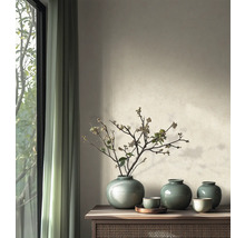 Minimalistisches Wohnzimmer mit Keramikvasen mit Krakelee-Glasur und getrockneten Zweigen auf einem Sideboard aus Holz neben einem Fenster.