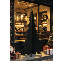 Schwarze Weihnachtsbaumsilhouette aus Holz oder Metall vor einem Schaufenster mit Weihnachtsdekoration und Geschenken.