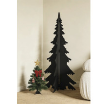 Minimalistischer schwarzer Weihnachtsbaum aus Holz neben einem kleinen geschmückten künstlichen Tannenbaum in einer hellen Zimmerecke.