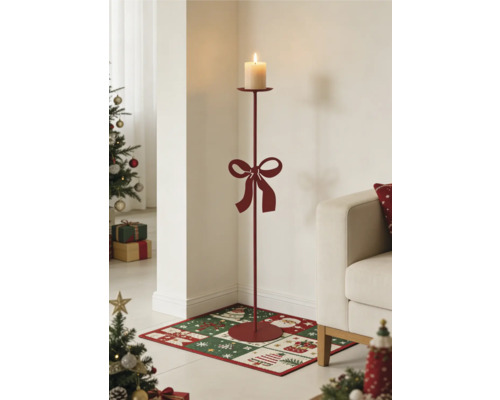 Hoher Bodenkerzenständer aus Metall mit Schleife und brennender Stumpenkerze in einem weihnachtlich dekorierten Wohnzimmer.