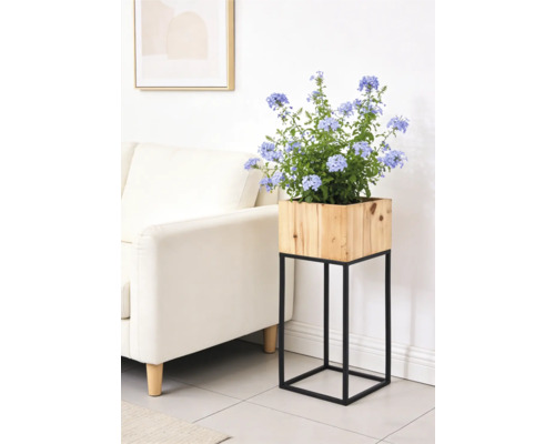 Moderner Blumenständer mit quadratischem Holz-Pflanzkasten auf schwarzem Metallgestell in einem hellen Wohnzimmer.