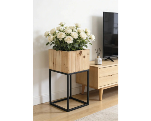Quadratischer Pflanzkasten aus Holz auf einem schwarzen Metallgestell mit weißen Rosen in einem hellen Wohnzimmer neben einem TV-Board.