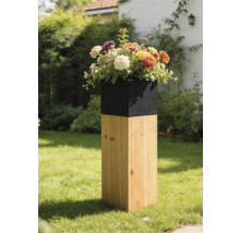 Moderner Pflanzkübel mit quadratischem Holzsockel und schwarzem Einsatz, bepflanzt mit bunten Blumen in einer Gartenlandschaft.
