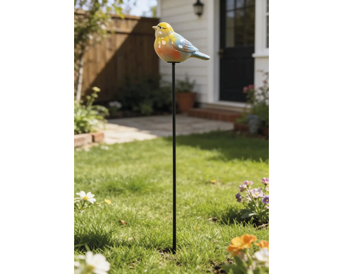 Gartenstecker mit buntem Vogel aus Keramik auf einem Metallstab, platziert in einem grünen Rasen vor einem Haus.