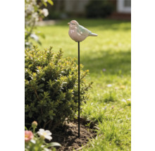 Gartenstecker mit Keramikvogel auf schwarzem Metallstab neben einem Strauch im Garten.