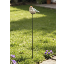 Gartenstecker aus Metall mit einer Vogelfigur aus Keramik in einem hellen Garten mit Rasen und Blumen.