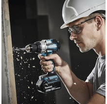 Handwerker mit Schutzhelm und Schutzbrille bohrt mit einem Makita Akku-Bohrschrauber 18 Volt Brushless in ein Holzbrett.