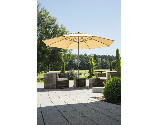 Beiger Sonnenschirm und graue Polyrattan-Gartenmöbel auf einer gepflasterten Terrasse in einem Garten.