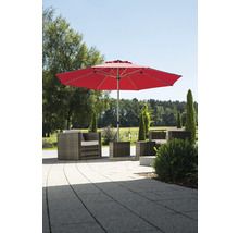 Roter Sonnenschirm über einer Lounge Sitzgruppe aus Polyrattan auf einer gepflasterten Terrasse im Garten.