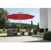 Moderner roter Sonnenschirm über einer Lounge-Sitzgruppe aus Polyrattan auf einer hellen, gepflasterten Terrasse im Garten.