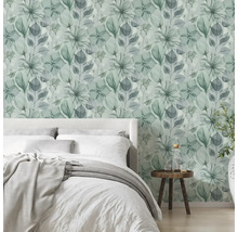 Modernes, helles Schlafzimmer mit floraler Vliestapete in Aquarell-Optik, einem Bett und einem Beistelltisch aus Holz.