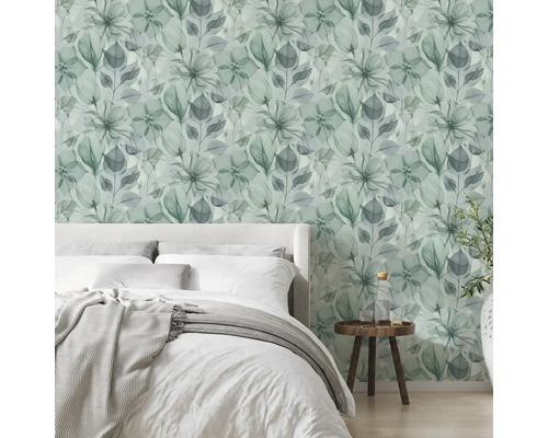 Modernes, helles Schlafzimmer mit floraler Vliestapete in Aquarell-Optik, einem Bett und einem Beistelltisch aus Holz.