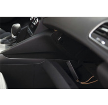 Kompaktes elektronisches Gerät in einem offenen Handschuhfach im Auto-Innenraum neben dem Schalthebel.