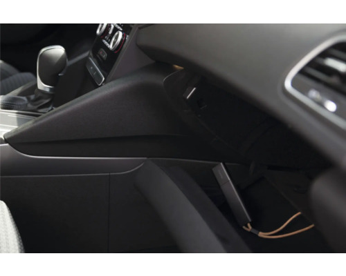 Kompaktes elektronisches Gerät in einem offenen Handschuhfach im Auto-Innenraum neben dem Schalthebel.
