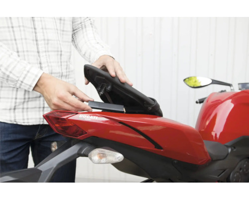 Einbau eines GPS-Trackers im Staufach unter der Sitzbank eines Motorrads.