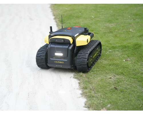 Yarbo autonomer Gartenroboter mit Kettenantrieb auf einer Rasenfläche neben einem Weg.