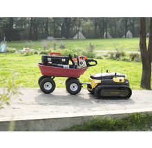 Yarbo Mehrzweck-Gartenroboter zieht einen roten Transportwagen mit Werkzeugkiste und Kettensäge auf einem Gartenweg.