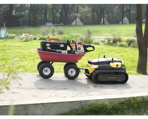 Yarbo Mehrzweck-Gartenroboter zieht einen roten Transportwagen mit Werkzeugkiste und Kettensäge auf einem Gartenweg.