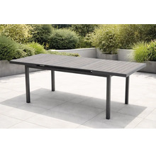 Moderner ausziehbarer Gartentisch aus anthrazitfarbenem Aluminium mit Lattenstruktur auf einer hellen gefliesten Terrasse im Garten.