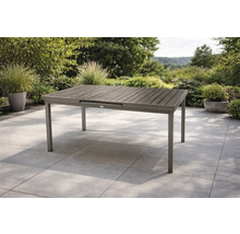 Rechteckiger Gartentisch mit Aluminiumgestell und Tischplatte in Holzoptik auf einer Terrasse.