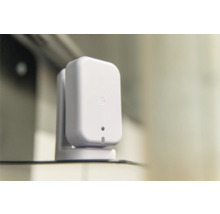 Kleiner weißer rechteckiger Smart-Home-Sensor mit abgerundeten Ecken auf einer passenden Halterung.