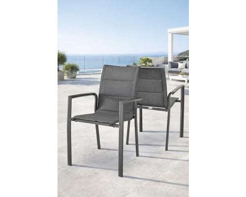 Zwei moderne Gartenstühle mit Armlehnen auf einer hellen Terrasse mit Meerblick.