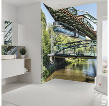 Modernes Badezimmer mit Fototapete der Wuppertaler Schwebebahn im Duschbereich, weißen Badmöbeln und hellem Design.