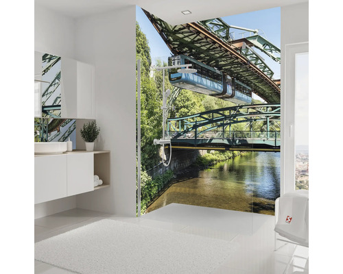 Modernes Badezimmer mit Fototapete der Wuppertaler Schwebebahn im Duschbereich, weißen Badmöbeln und hellem Design.
