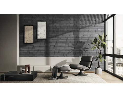 Modernes Wohnzimmer mit Wandverblendern in dunkelgrauer Backsteinoptik, einem Sessel mit Hocker, großem Fenster und einer Zimmerpflanze.