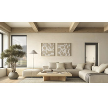 Helles, modern eingerichtetes Wohnzimmer mit beigem Ecksofa, Holztisch, zwei abstrakten Wandbildern, Stehlampe und Pflanze unter Holzdeckenbalken.