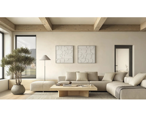 Helles minimalistisches Wohnzimmer mit beigem Ecksofa, Couchtisch aus Holz, Stehleuchte und Wandbildern. Sichtbare Deckenbalken aus Holz.