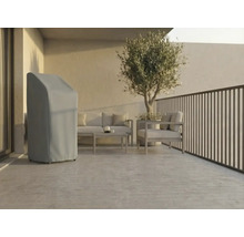 Helle, moderne Terrasse mit einer grauen Abdeckhaube für Gartengeräte, Loungemöbeln aus Metall und einem Olivenbaum im Topf.